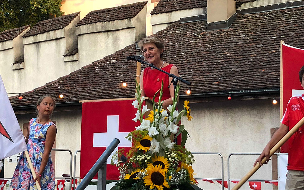 La consigliera federale sul palco ornato di fiori.