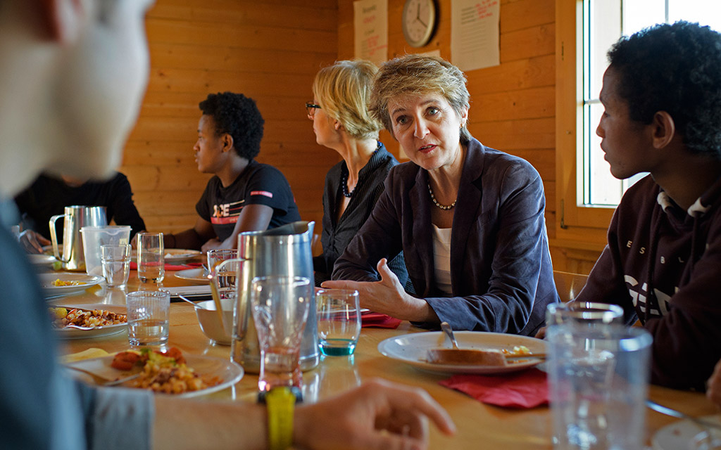 Bundesrätin Simonetta Sommaruga unterhält sich anlässlich ihres Besuchs im Kinderdorf Pestalozzi beim gemeinsamen Mittagessen mit unbegleiteten minderjährigen Asylsuchenden